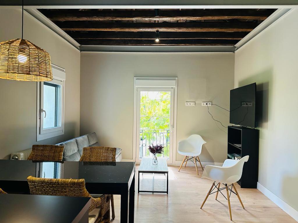 sala de estar con mesa negra y sillas blancas en La Casita de Lauri, en El Escorial