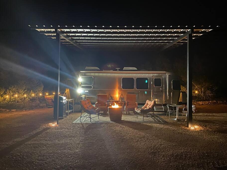 un camper parcheggiato sotto una tenda di notte di Airstream Alfresco a Fredericksburg