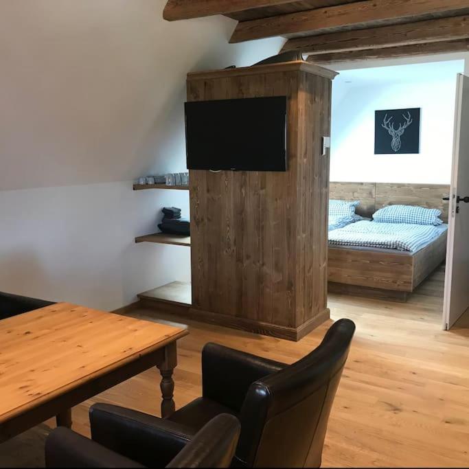 a living room with a table and a bed at Ferienwohnung im Berghüttenstyle in Bad Wörishofen