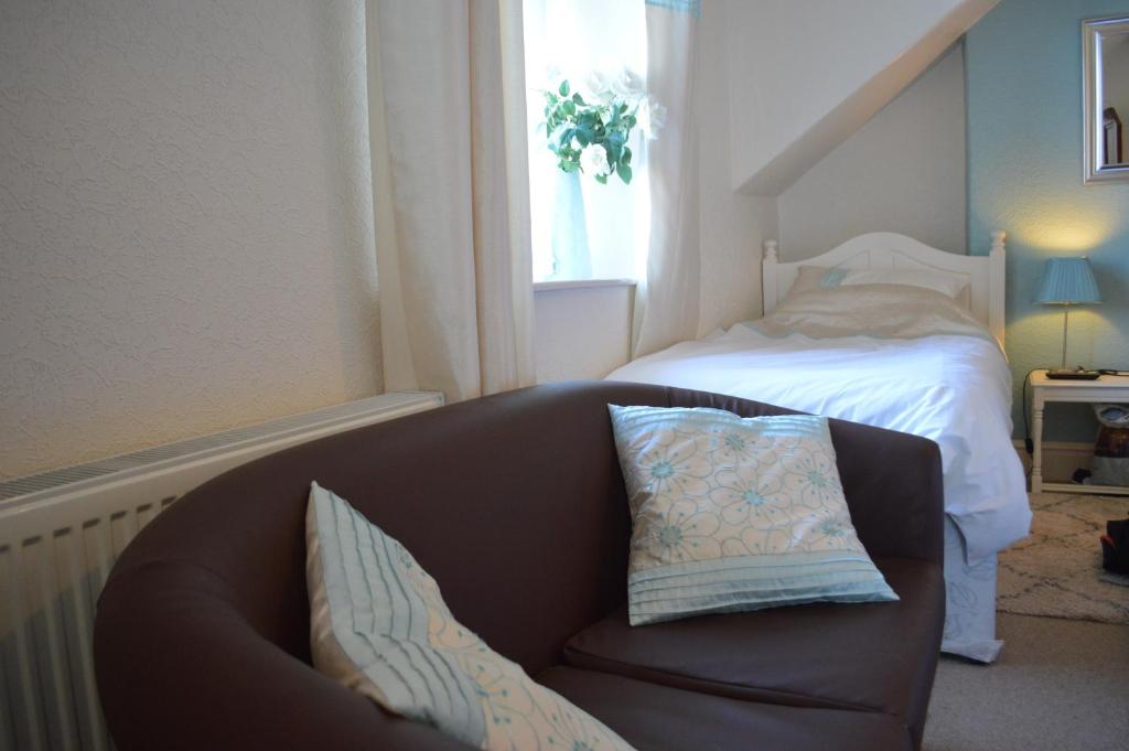 a living room with a couch and a bed at Witchingham B&B in Holyhead