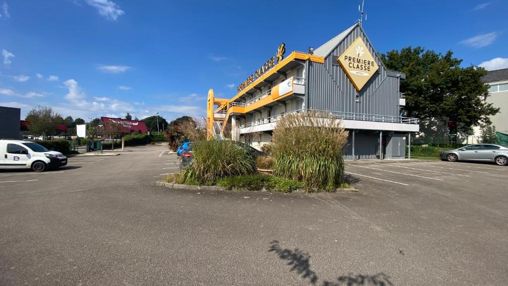 a parking lot in front of a large building at Premiere Classe Quimper in Quimper