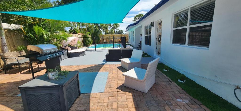 a backyard with a grill and a house at Prime Location-Equipped House W Pool & Patios, Near the Beaches, Ideal for Small Families, Coastal Haven in Fort Lauderdale