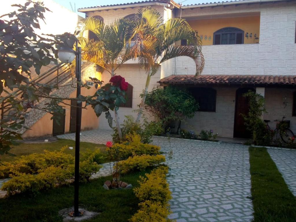 a house with a street light in front of a yard at Quitinetes dos Ipês in Barra de São João