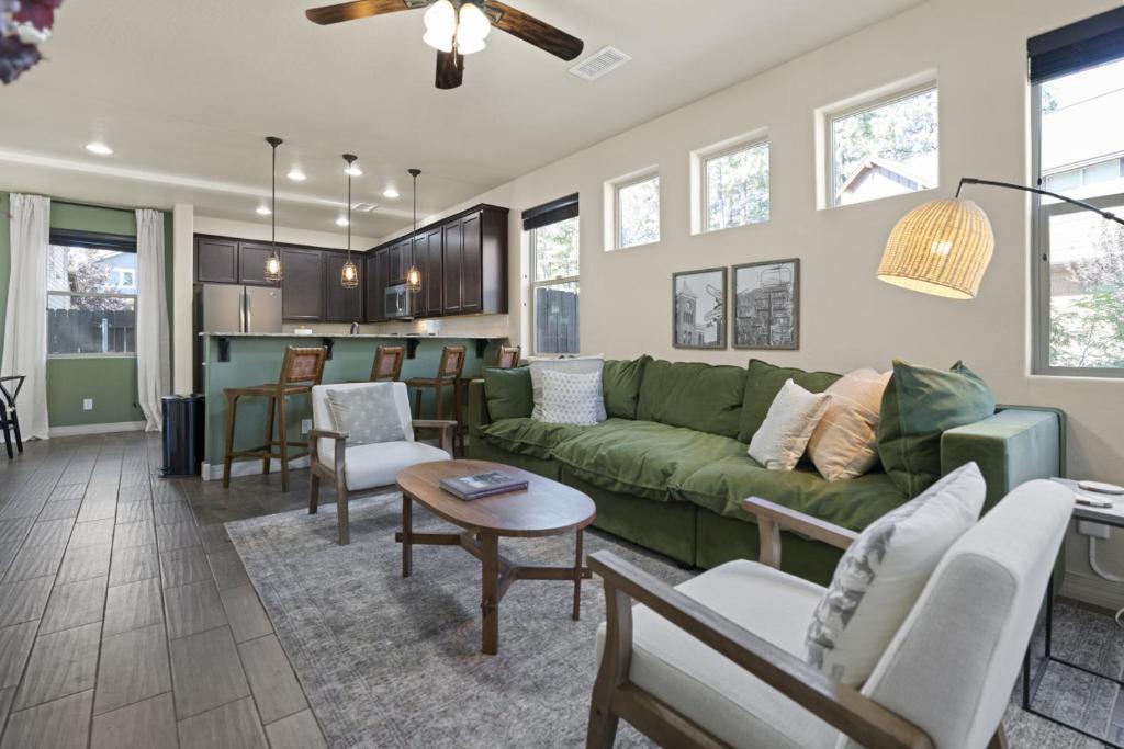 a living room with a green couch and a kitchen at The Sage Wood House in Flagstaff