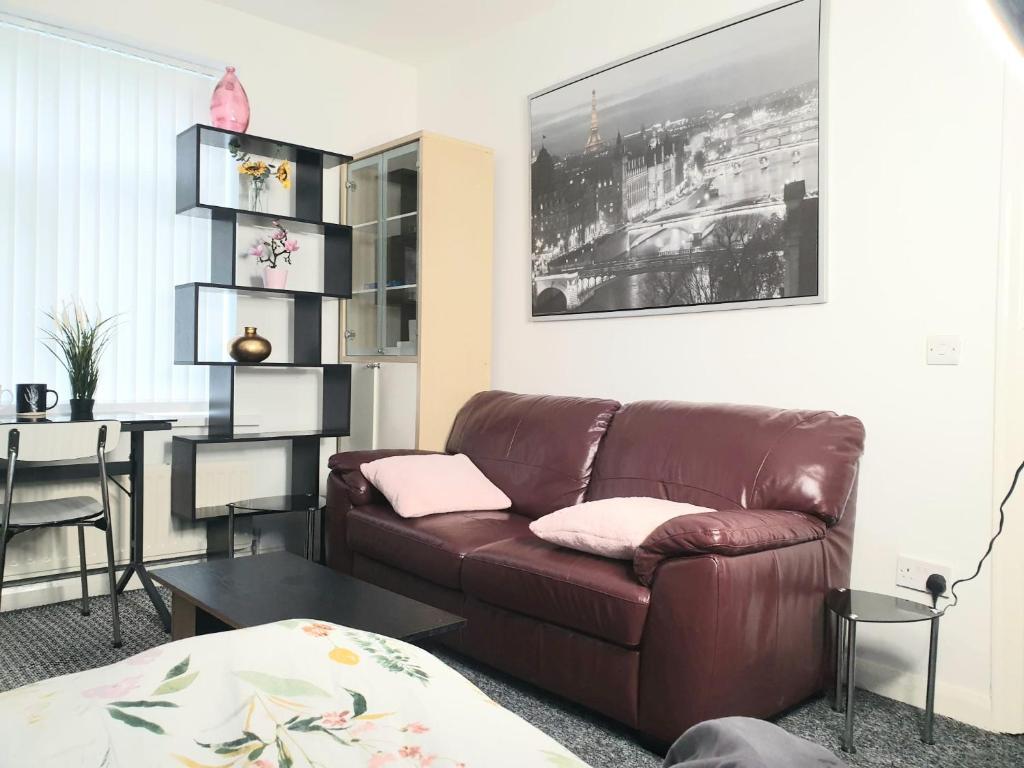 a living room with a brown couch and a table at The Quiet Room in Newcastle upon Tyne