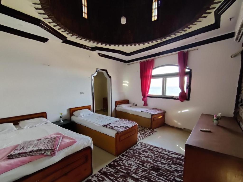 um quarto amplo com 2 camas e um espelho em New Saraya Camp em Nuweiba