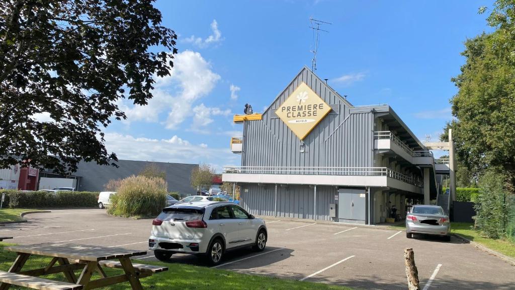 a car parked in a parking lot in front of a building at Premiere Classe Quimper in Quimper