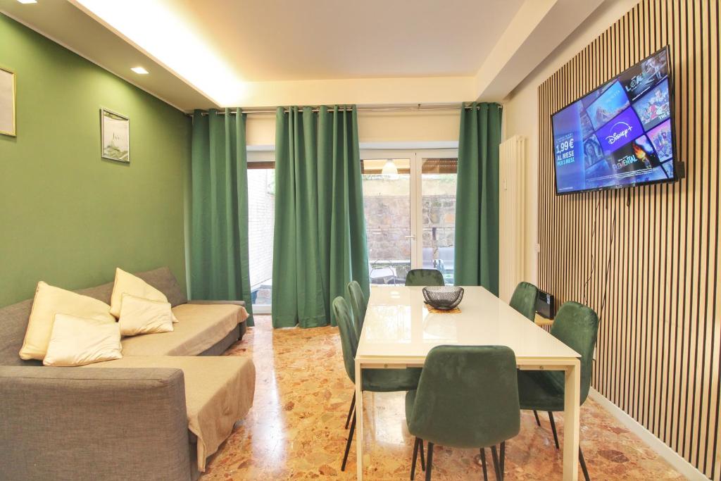 un soggiorno con divano, tavolo e TV di Delicious 2 Bed Room Apartment and Garden by YH a Roma
