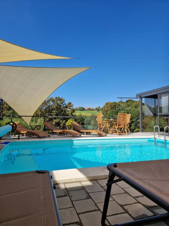 a swimming pool with a view of a house at Aura Lux Holiday Home with Pool in Lopatinec