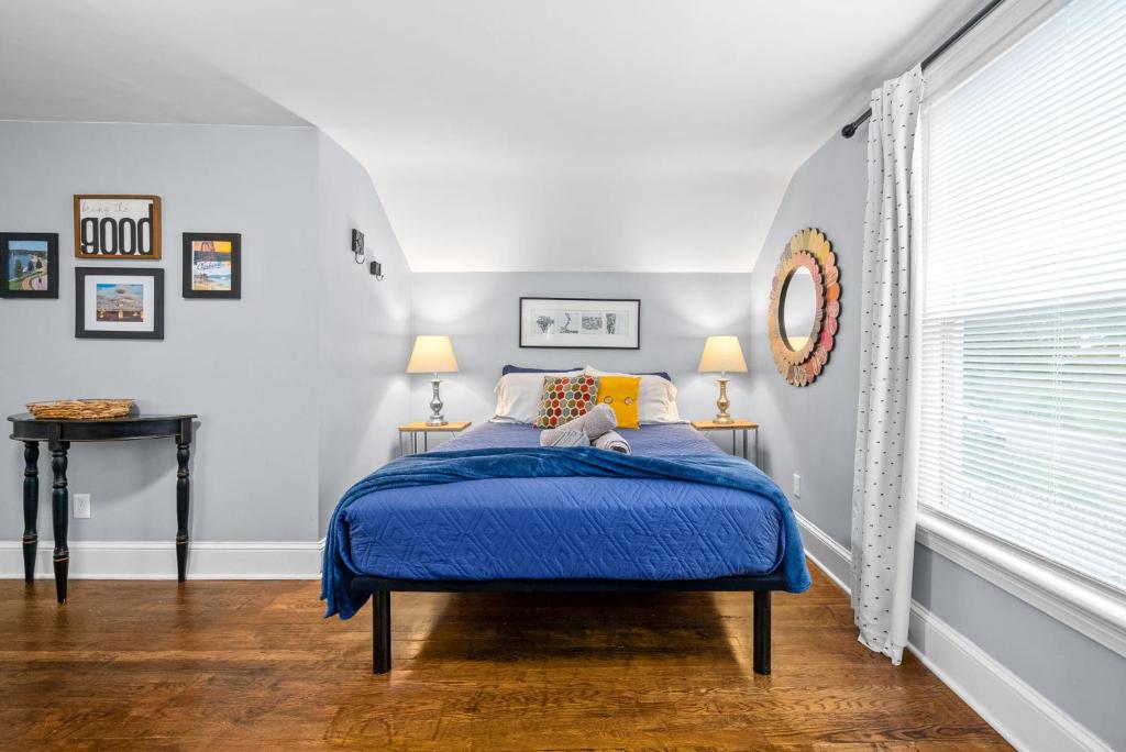 a bedroom with a bed with a blue comforter at The Loft At Madison Terrace - Private Unit in Clarksville