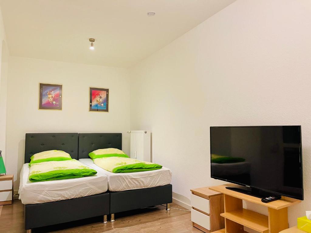 een slaapkamer met een bed en een flatscreen-tv bij Etzel Ferienwohnung in Würzburg