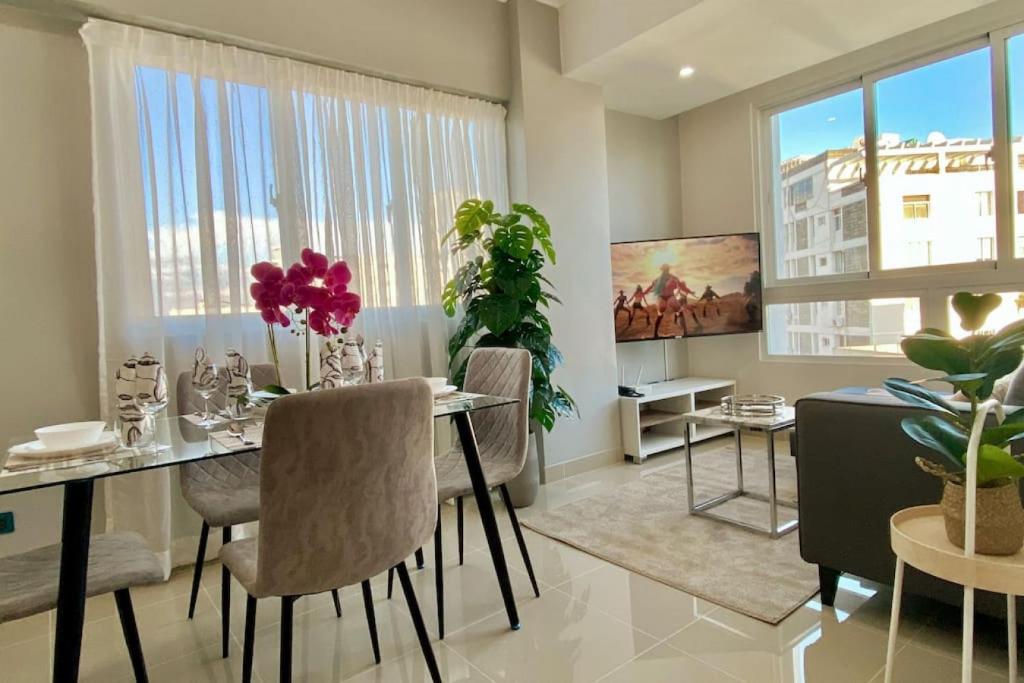 uma sala de jantar com uma mesa e cadeiras num quarto em Cozy City Center Condo Full AC em Santo Domingo