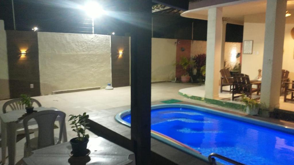 uma grande piscina numa sala de estar com uma mesa e uma mesa em Pousada Sua Casa na Barra de São Miguel