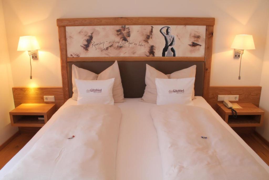 a bedroom with a large bed with white sheets and pillows at Garden & SPA Hotel Das Götzfried in Regensburg