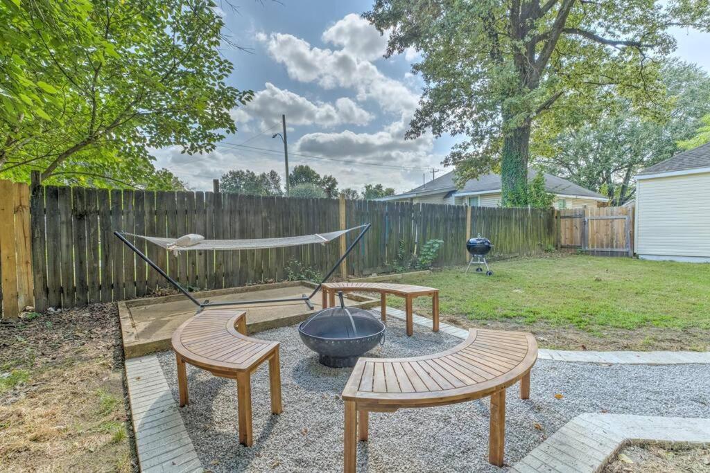a backyard with a grill and benches and a fence at Bright & Charming Cooper Young Cottage with Fire Pit and Porch Swing in Memphis