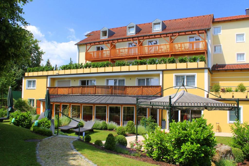 a large yellow building with a balcony at Garden & SPA Hotel Das Götzfried in Regensburg