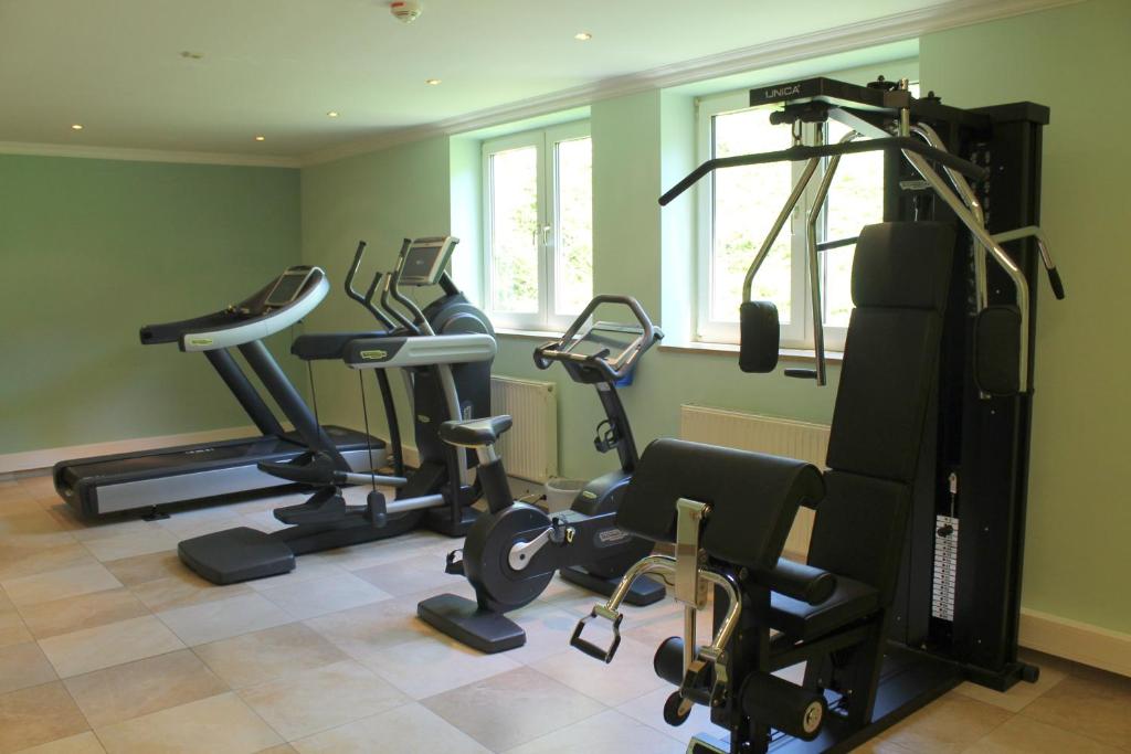 a gym with several tread machines in a room at Garden & SPA Hotel Das Götzfried in Regensburg