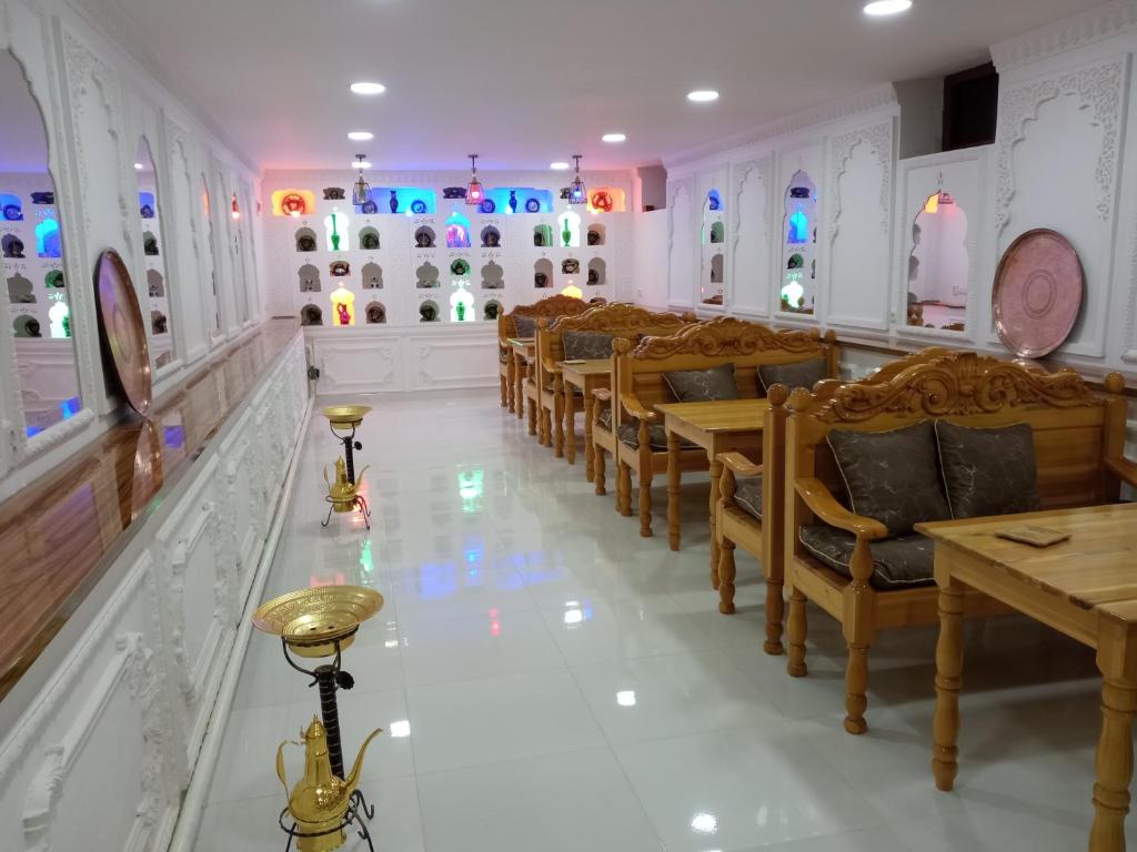 un comedor con sillas, mesas y luces en Boutique Hotel Parvina, en Bukhara