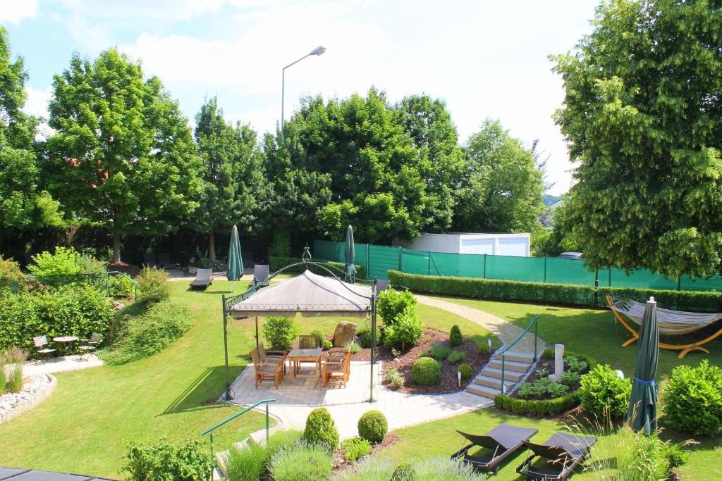 a garden with a table and a gazebo at Garden & SPA Hotel Das Götzfried in Regensburg