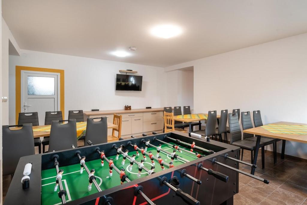 Cette chambre comprend une table de ping-pong et des chaises. dans l'établissement Rezidencia Podhájska, à Podhájska