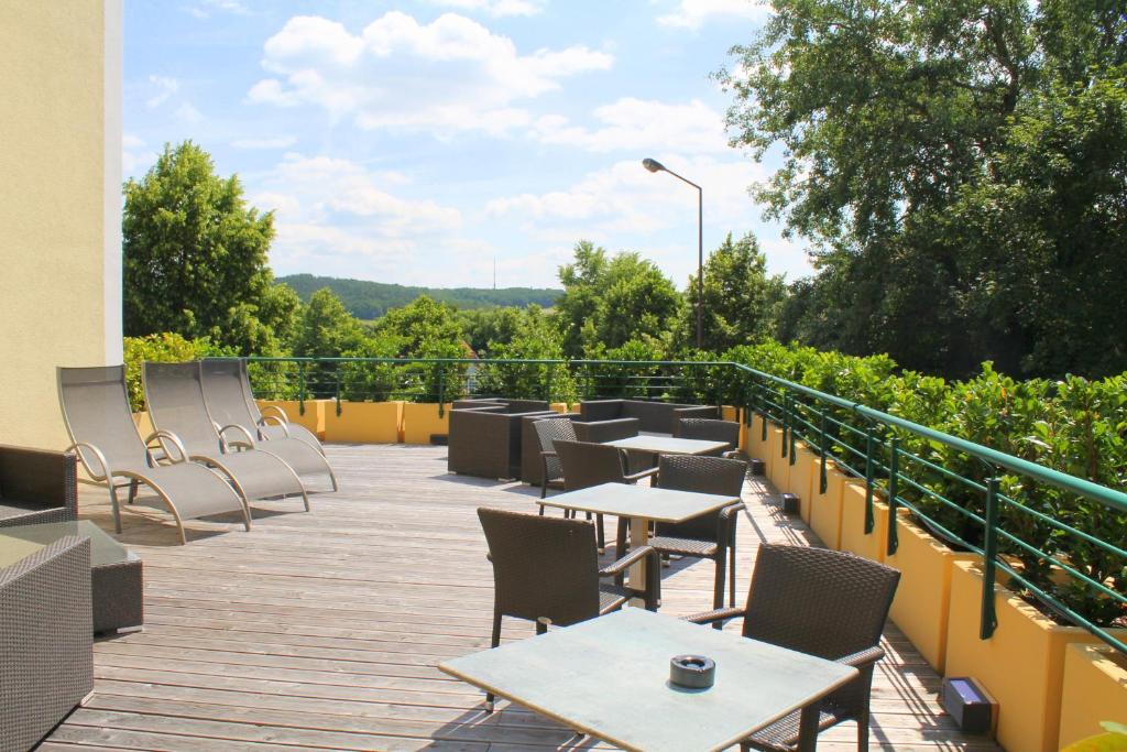 a patio with tables and chairs on a balcony at Garden & SPA Hotel Das Götzfried in Regensburg