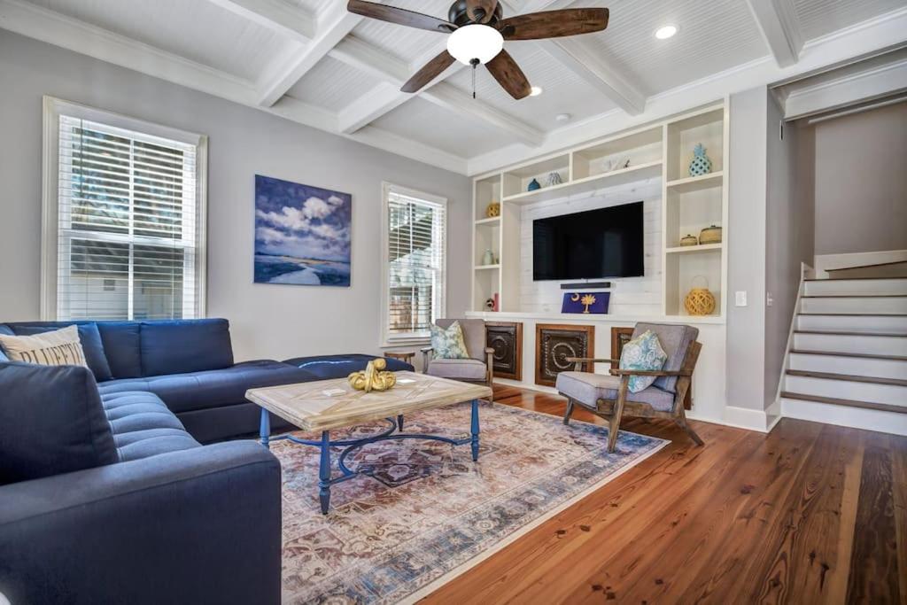 un soggiorno con divano blu e ventilatore a soffitto di Bluffton Village Home-4BR Heart of Old Town Luxury a Bluffton