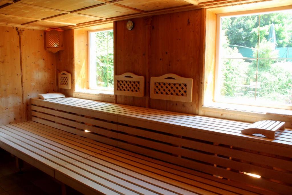 a sauna with two windows in a wooden cabin at Garden & SPA Hotel Das Götzfried in Regensburg