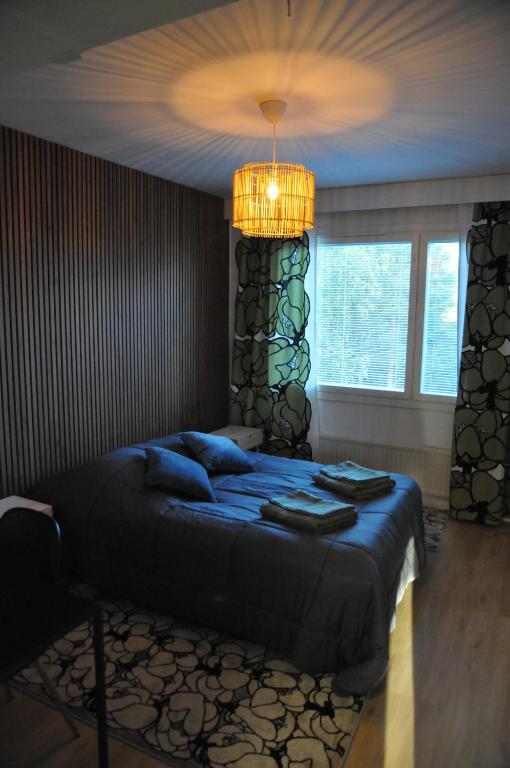 a bedroom with a bed and a chandelier at Apartment for six near Railway station in Rovaniemi