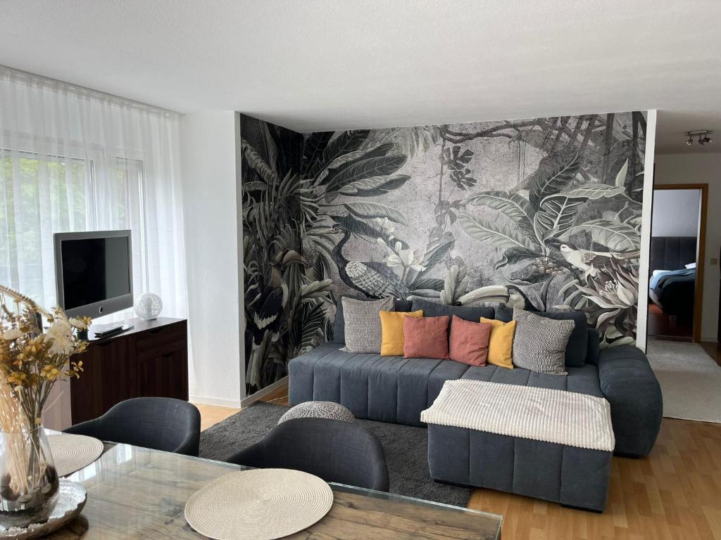 a living room with a couch and a wall mural at Ferienwohnung Milla in Weissach Im Tal