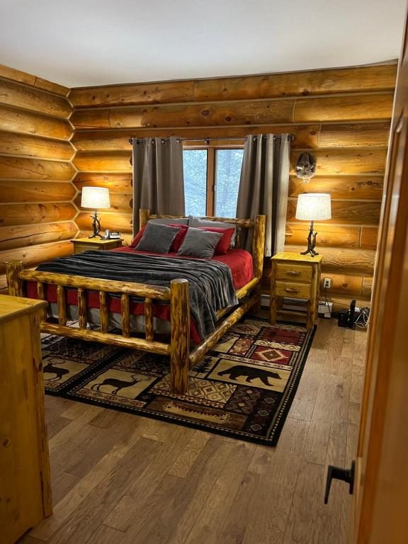 una camera con un letto in una baita di tronchi di Cerul Mare Cabin a Gallatin Gateway