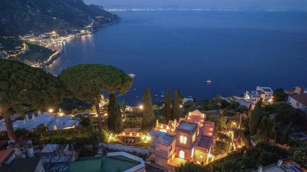 a view of a city at night with the ocean at Villa Barluzzi in Ravello