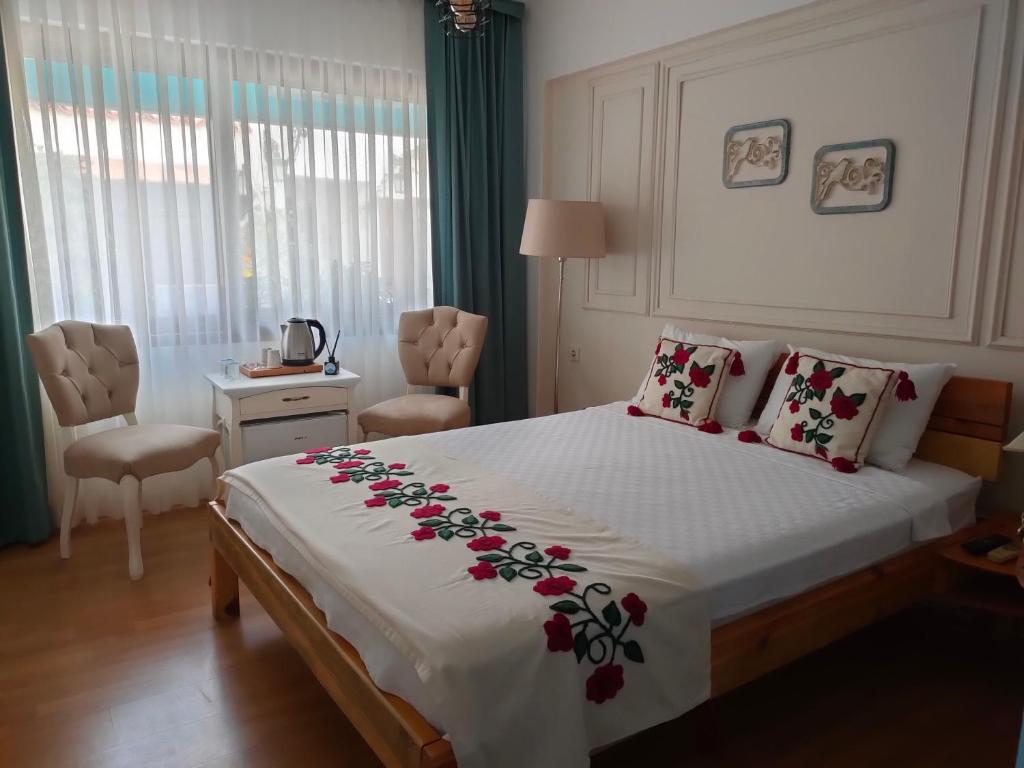 een slaapkamer met een groot bed met bloemen erop bij Sığacık Duru Pansiyon in Seferihisar