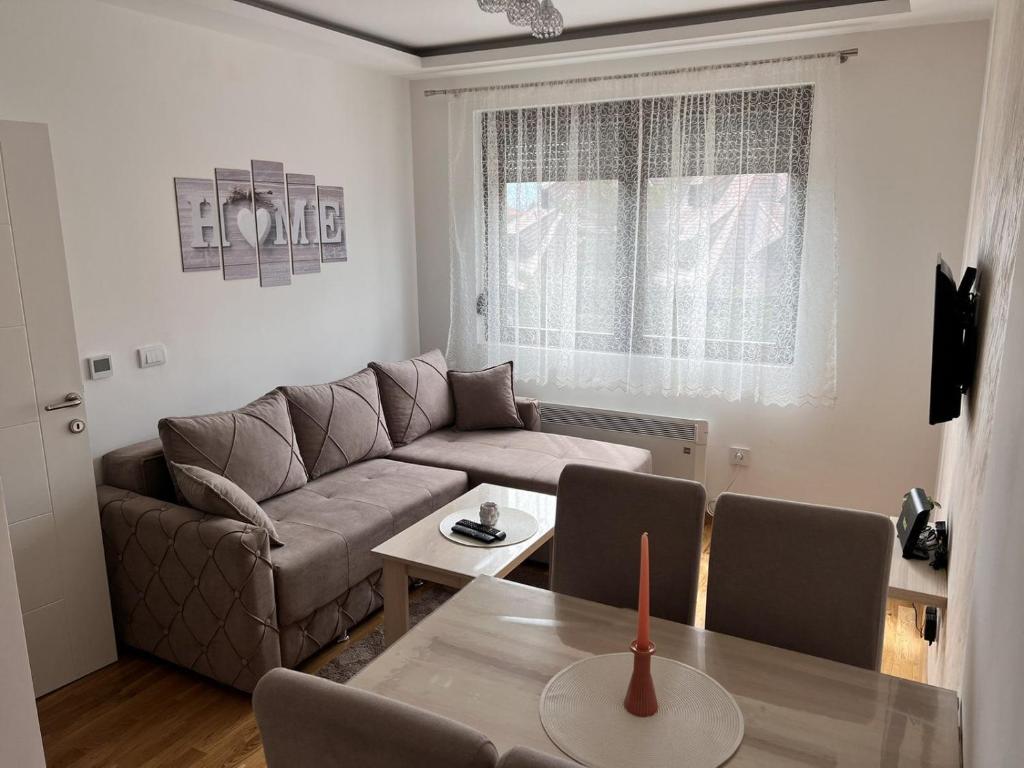 uma sala de estar com um sofá e uma mesa em Apartman Stevanovic Zlatibor em Zlatibor