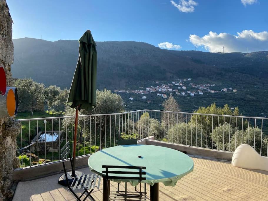 patio con tavolo e ombrellone verde di Casa Pero Soares a Guarda