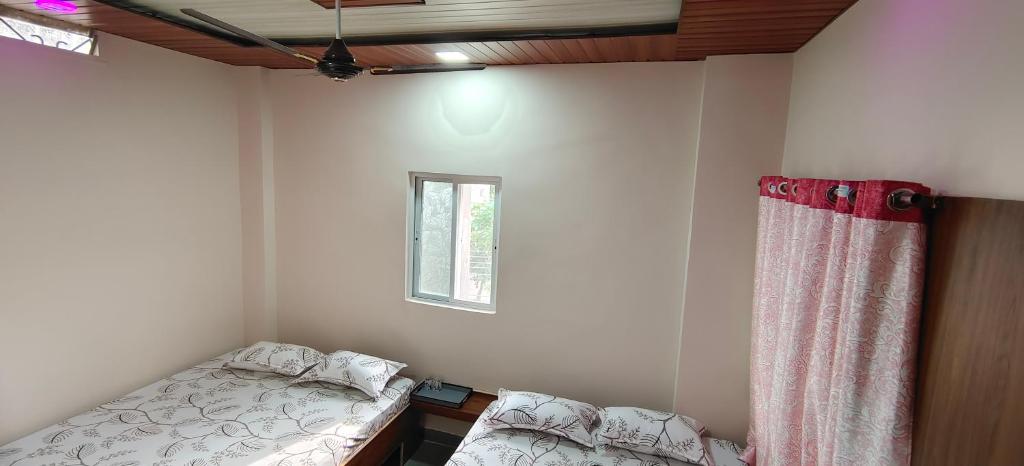 a small bedroom with a bed and a window at HOTEL ANJALI in Ujjain
