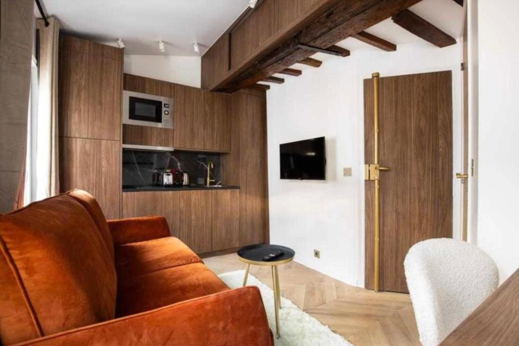 sala de estar con sofá marrón y mesa en Lovely studio - Pigalle Moulin Rouge, en París