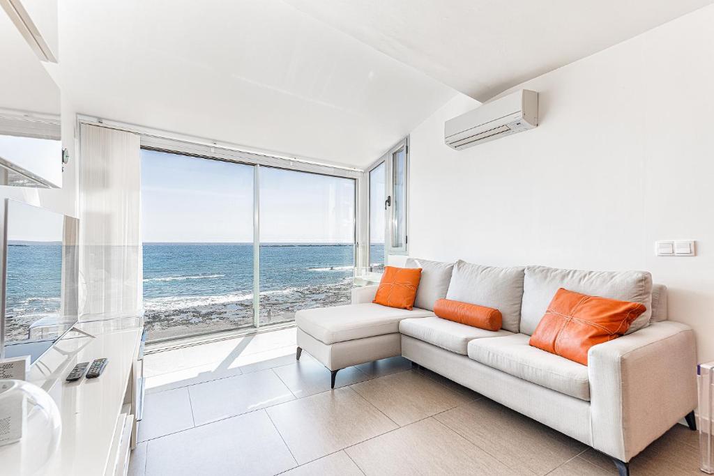 a living room with a couch and a view of the ocean at Luxury First Line Apartment. in Salinetas