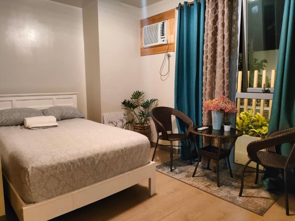 - une chambre avec un lit, une table et des chaises dans l'établissement The Verdin at Maple Grove, à Cavite