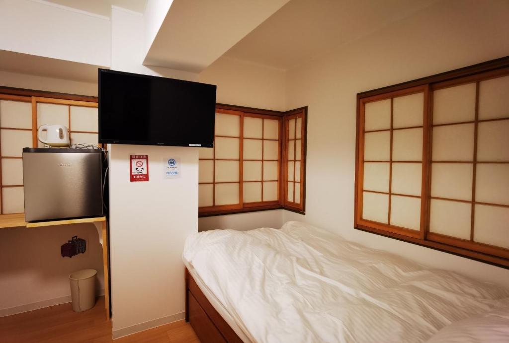 a room with a bed and a television on a wall at belle via tokyo - Vacation STAY 58509v in Tokyo