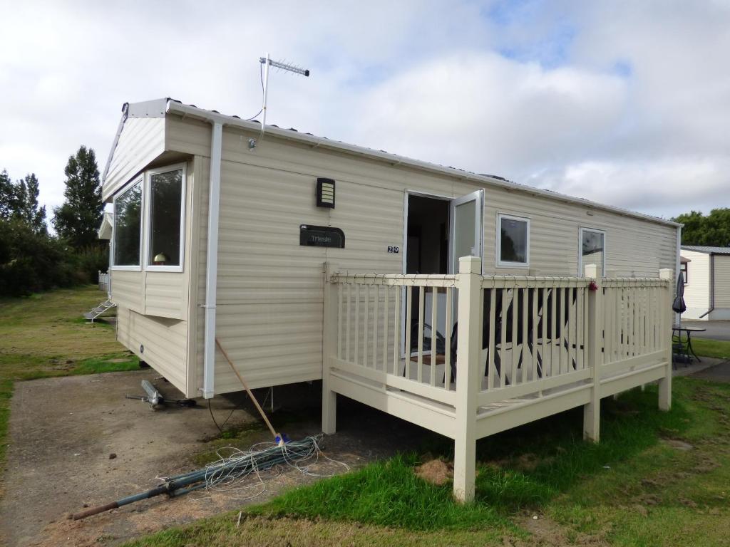 a white mobile home with a porch at Orchards 29 at Southview Leisure Park in Skegness