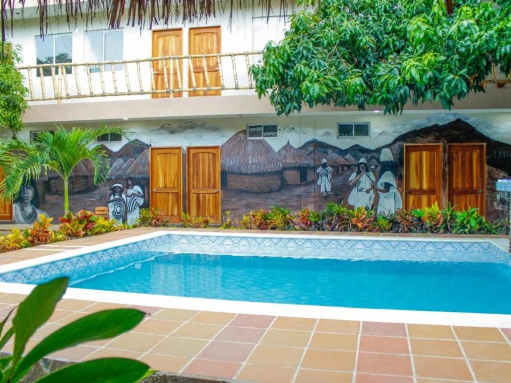 a mural on the side of a building with a swimming pool at Hostal Los Arhuacos in Santa Marta