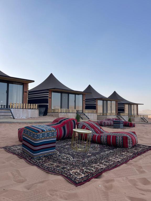 a group of pillows on a rug in front of a house at Rashed Luxury Camp in Wadi Rum