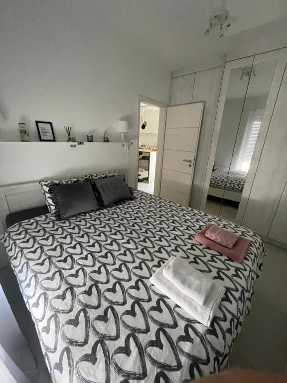 een slaapkamer met een zwart-wit bed en een spiegel bij Apartman Rose Residency - SELF CHECK IN, FREE PARKING in Osijek