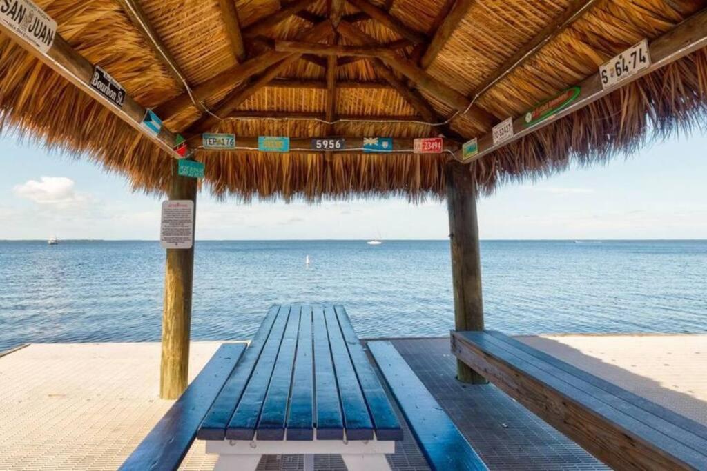 a bench under a straw umbrella on the beach at Serenity at Moon Bay! in Key Largo