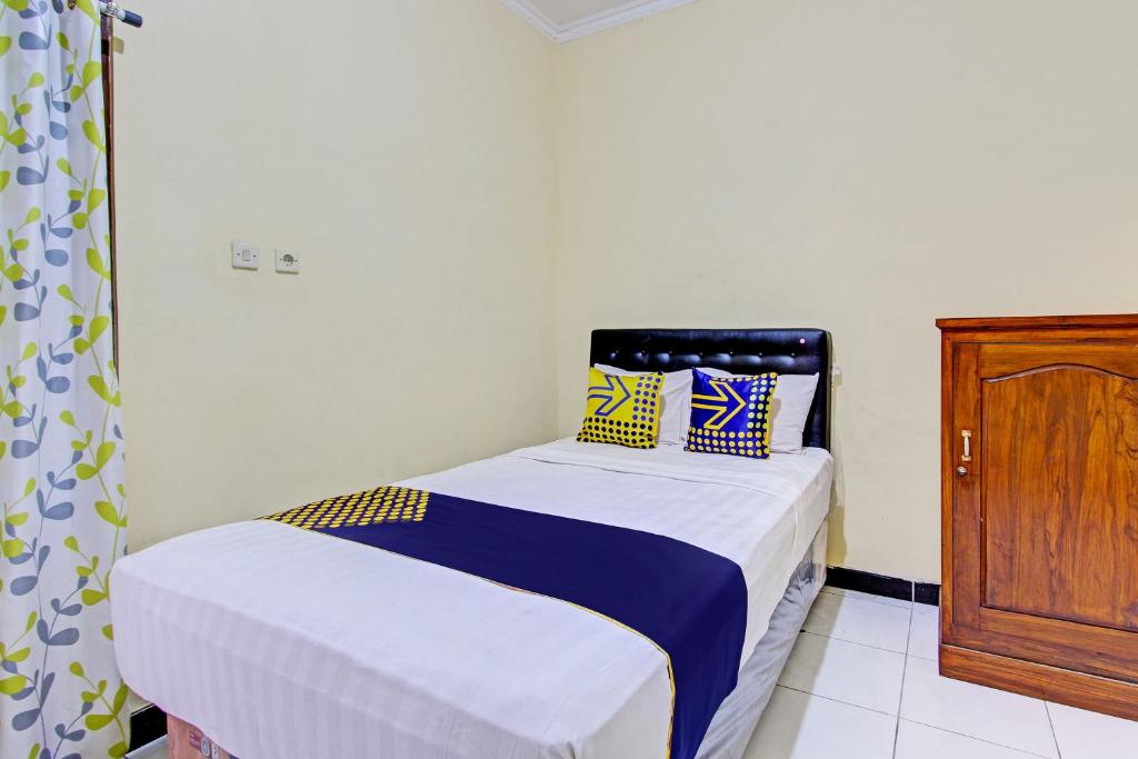 una piccola camera con letto e armadio in legno di SPOT ON 93007 Guest House Lestari a Prambanan