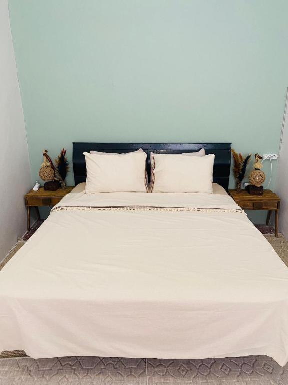 ein großes weißes Bett in einem Zimmer mit 2 Tischen in der Unterkunft Tarihi kent ev in Mardin