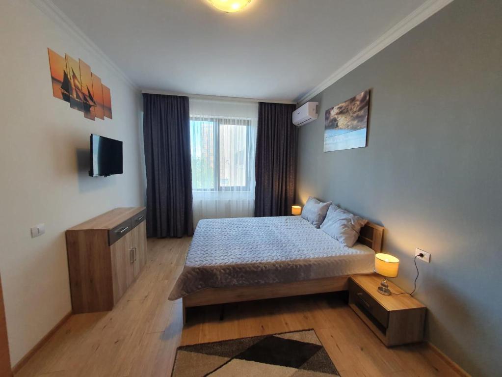 um quarto com uma cama e uma televisão em Solid Residence Apartments Mamaia em Mamaia