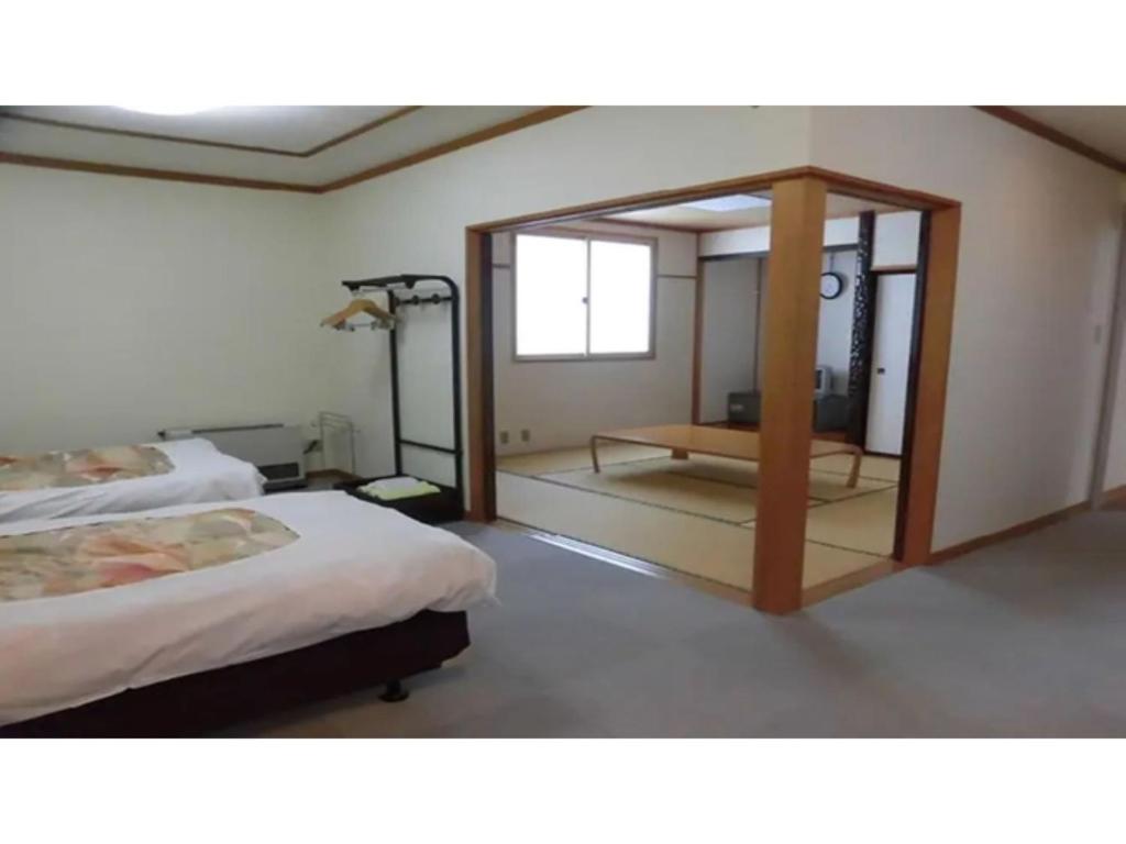 una camera con due letti e uno specchio di Asakusa Sanso - Vacation STAY 52030v a Uonuma
