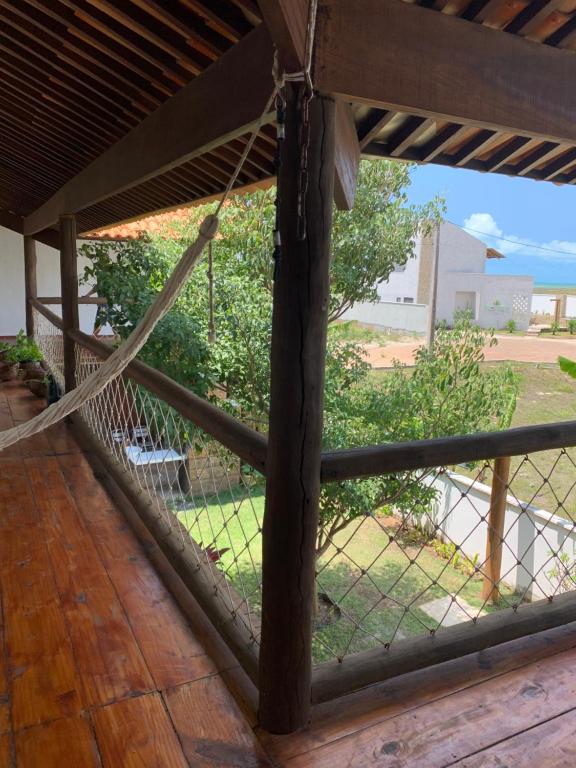 um alpendre com uma cerca e vista para um quintal em Flat amplo em condominio beira mar em São Miguel do Gostoso