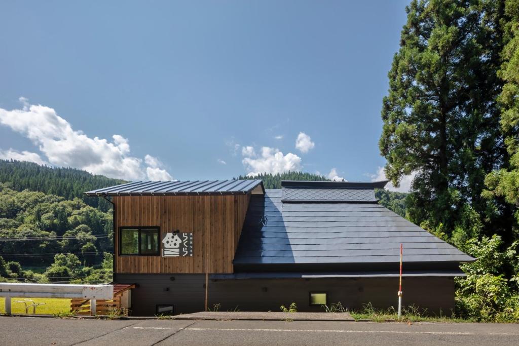 的住宿－Okuaga Shichimeian Rakura - Vacation STAY 67125v，一座黑屋顶和一棵树的房子